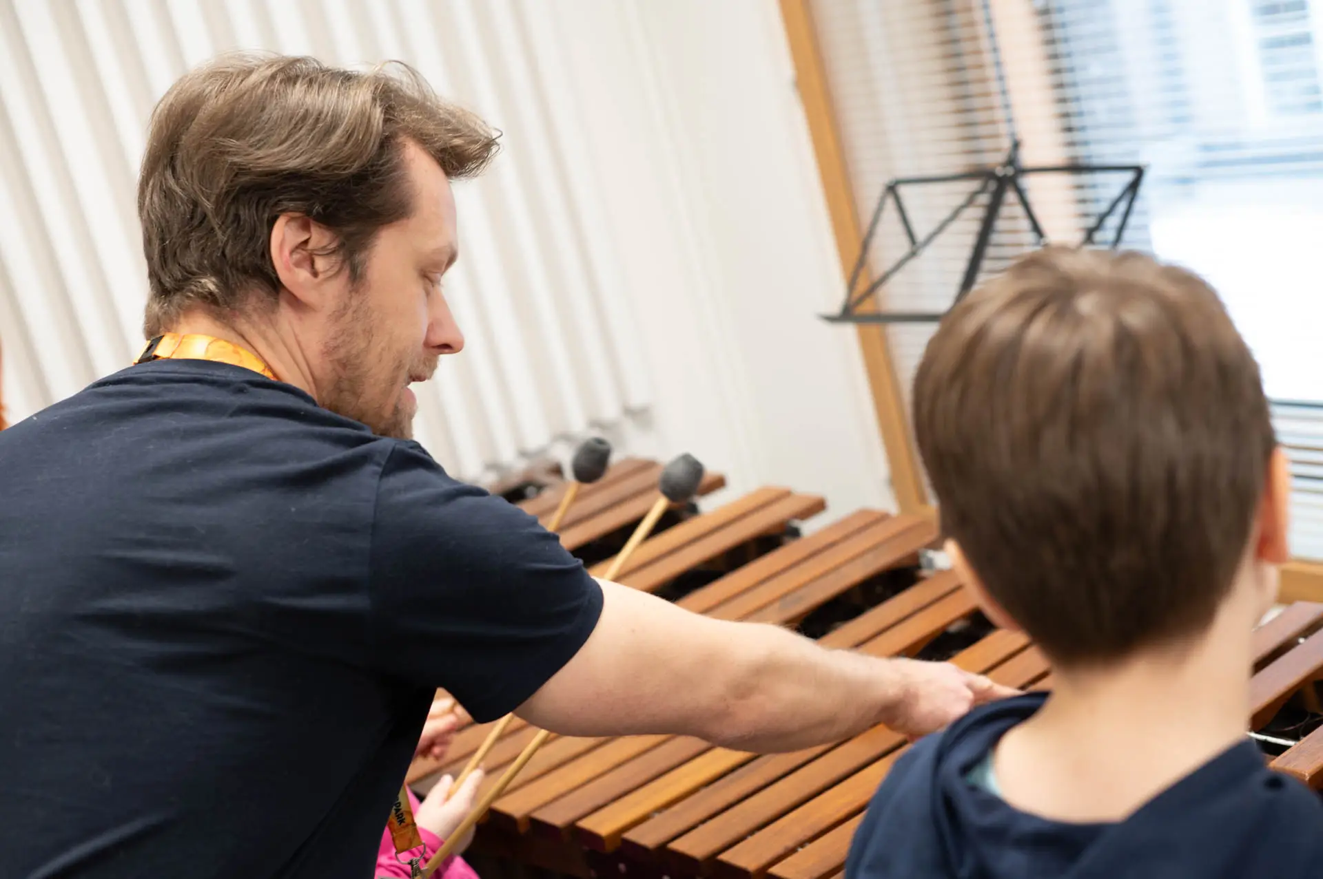 Musiikinopettaja opettaa nuorta poikaa soittamaan 